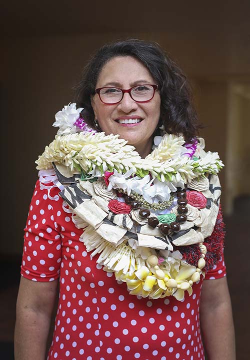 Polynesian woman wearing several flower leis